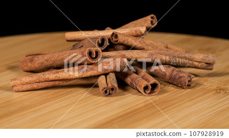 Close-up footage of cinnamon sticks on black background. Close-up footage of cinnamon sticks on black background. 107928919
