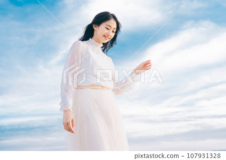 Woman portrait on blue sky background Woman portrait on blue sky background 107931328