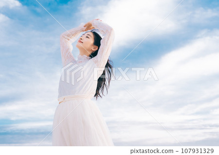 Woman portrait on blue sky background Woman portrait on blue sky background 107931329