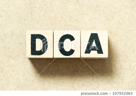 Alphabet letter block in word DCA (Abbreviation of Dollar-cost averaging) on wood background 107932063
