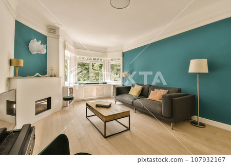 a living room with teal blue walls and white trim on the walls, wood flooring and fireplaces 107932167