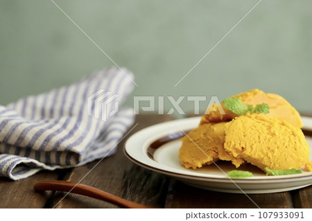 Homemade baked pumpkin pudding garnished with mint Homemade baked pumpkin pudding garnished with mint 107933091