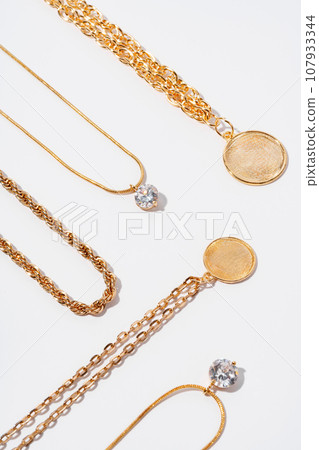 Set of gold chains with pendant on white background 107933344