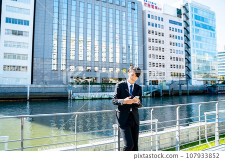 Businessman looking at a smartphone 107933852