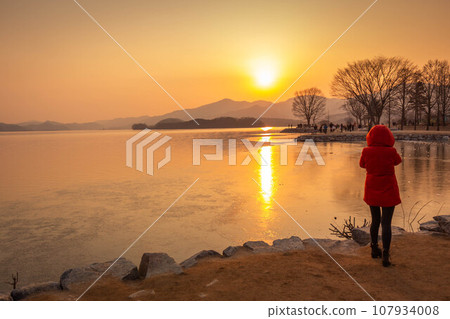 Tourists taking pictures of a frozen lake in South Korea in winter in sunset at Dumulmeori, Yangpyeong, South Korea. Tourists taking pictures of a frozen lake in South Korea in winter in sunset at Dumulmeori, Yangpyeong, South Korea. 107934008