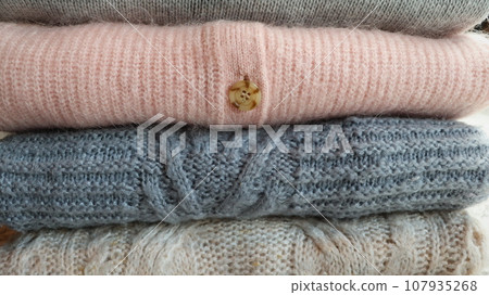 Stack of warm cozy knitted women's sweaters . Autumn or winter comfort concept 107935268