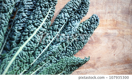 Kale cabbage leaves directly above on dark stone background. Kale cabbage leaves directly above on dark stone background. 107935300
