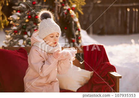 Girl on decorated Christmas street in winter 107935353