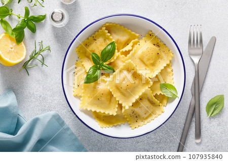 Ravioli with ricotta cheese and fresh basil, top view 107935840