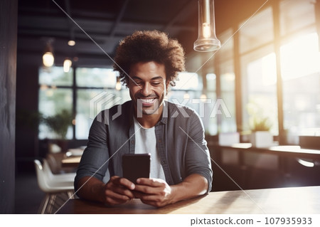 Portrait of cheerful African American businessman in casual clothes with smartphone at a table. Happy smiling mature man, successful entrepreneur or employee working in office or coworking cafe. Portrait of cheerful African American businessman in casual clothes with smartphone at a table. Happy smiling mature man, successful entrepreneur or employee working in office or coworking cafe. 107935933
