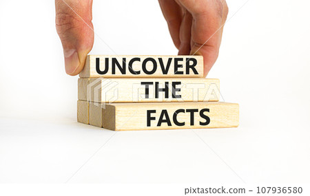 Uncover the facts symbol. Concept words Uncover the facts on wooden blocks on a beautiful white table white background. Businessman hand. Business and uncover the facts concept. Copy space. 107936580