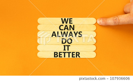 We make it better symbol. Concept words We can always do it better on wooden stick. Beautiful orange table orange background. Businessman hand. Business we make it better concept. Copy space. 107936606