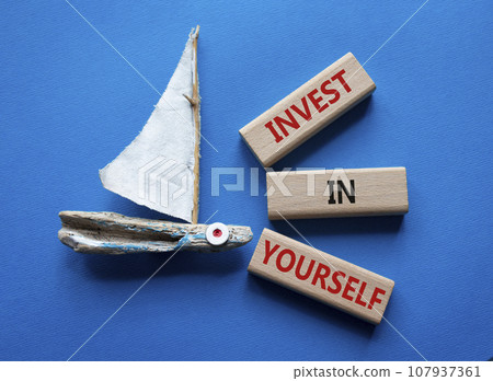 Invest in Yourself symbol. Concept words Invest in Yourself on wooden blocks. Beautiful blue background with boat. Business and Invest in Yourself concept. Copy space. 107937361