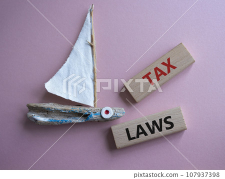 Tax Laws symbol. Concept word Tax Laws on wooden blocks. Beautiful pink background. Business and Tax Laws concept. Copy space Tax Laws symbol. Concept word Tax Laws on wooden blocks. Beautiful pink background. Business and Tax Laws concept. Copy space 107937398