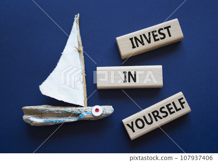 Invest in Yourself symbol. Concept words Invest in Yourself on wooden blocks. Beautiful deep blue background with boat. Business and Invest in Yourself concept. Copy space. 107937406
