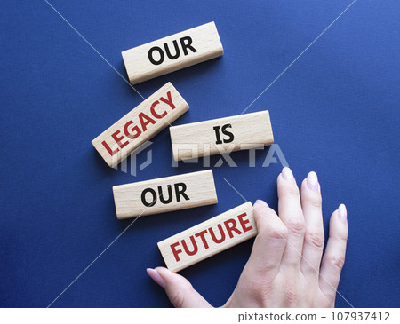 Our Legacy is our Future symbol. Concept words Our Legacy is our Future on wooden blocks. Businessman hand. Beautiful deep blue background. Business and Our Legacy is our Future concept. Copy space Our Legacy is our Future symbol. Concept words Our Legacy is our Future on wooden blocks. Businessman hand. Beautiful deep blue background. Business and Our Legacy is our Future concept. Copy space 107937412