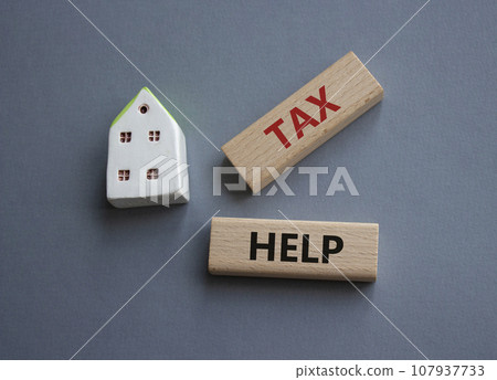 Tax Help symbol. Concept word Tax Help on wooden blocks. Beautiful grey background. Business and Tax Help concept. Copy space Tax Help symbol. Concept word Tax Help on wooden blocks. Beautiful grey background. Business and Tax Help concept. Copy space 107937733