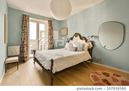 a bedroom with blue walls and wood flooring, including a large bed in the center of the room is a mirror on the a bedroom with blue walls and wood flooring, including a large bed in the center of the room is a mirror on the 107938560