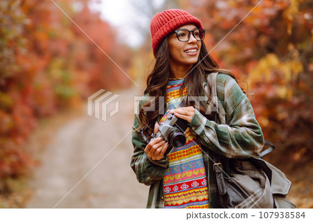 Smiling woman enjoying autumn weather. Rest, relaxation, lifestyle concept. 107938584