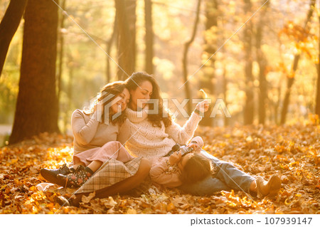 The homosexual family playing with her daughter in the autumn forest. The adventure is more fun. 107939147