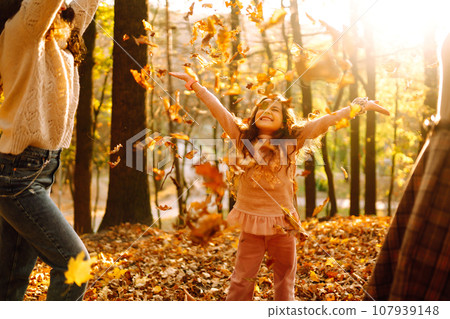 The homosexual family playing with her daughter in the autumn forest. The adventure is more fun. 107939148