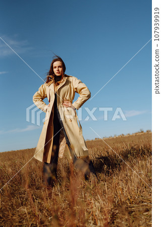 Young woman in stylish clothes posing in autumn field. Nature, fashion, lifestyle. Travel. 107939919