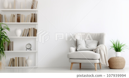 A cozy living room with a white bookshelf and a gray armchair. The bookshelf is filled with books, a vase, and a clock. A white throw blanket adds warmth to the armchair. A green plant in a woven A cozy living room with a white bookshelf and a gray armchair. The bookshelf is filled with books, a vase, and a clock. A white throw blanket adds warmth to the armchair. A green plant in a woven 107939994