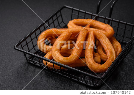 Delicious sweet churos with powdered sugar and cream inside 107940142