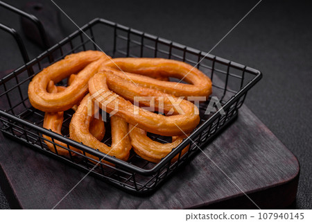 Delicious sweet churos with powdered sugar and cream inside Delicious sweet churos with powdered sugar and cream inside 107940145