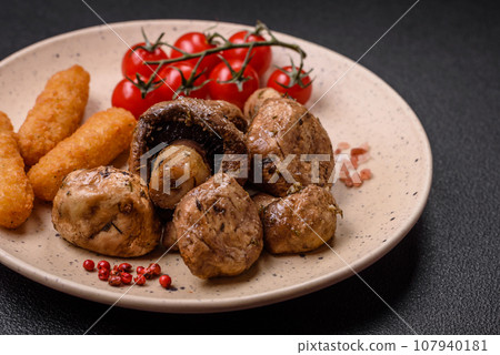 Delicious juicy whole champignons baked on the grill with salt and spices 107940181