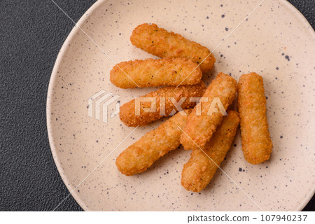 Delicious crispy cheese sticks with mozzarella, salt and spices 107940237