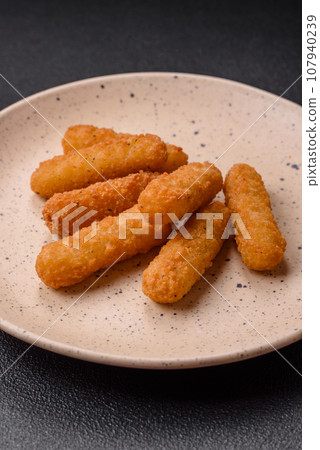 Delicious crispy cheese sticks with mozzarella, salt and spices 107940239