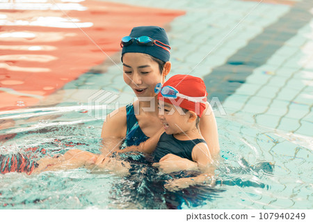 Swimming coach and 4 year old child 107940249