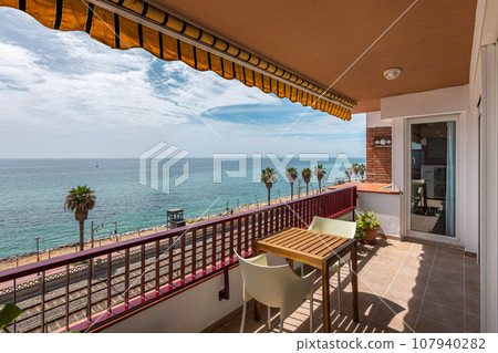 Terrace with table against city beach in Vilassar de Mar Terrace with table against city beach in Vilassar de Mar 107940282