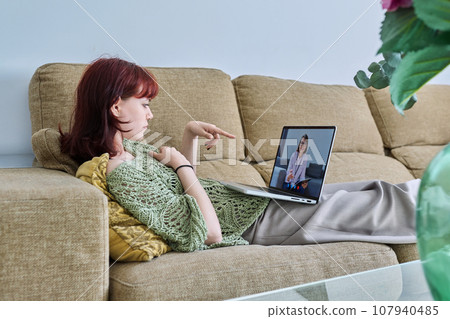 Online therapy, young female lying at home having video conference with psychologist Online therapy, young female lying at home having video conference with psychologist 107940485