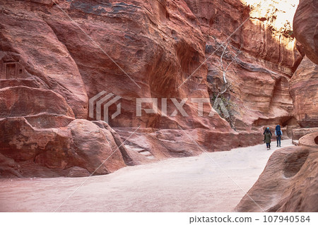 Kayon Sik. Bewin, dressed in traditional clothing, walks along the canyon wall. Petra Jordan Kayon Sik. Bewin, dressed in traditional clothing, walks along the canyon wall. Petra Jordan 107940584