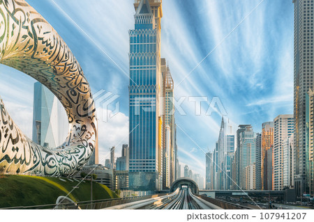 Museum Of Future. Night View. Unique Futuristic Design. Dubai, UAE. Metro Railway Among Among Glass Skyscrapers In Dubai. Traffic On Street In Dubai. Cityscape Skyline. Urban Background 107941207