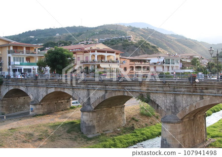 view of the town of Diamante, Cosenza, Calabria, Italy with famous bridge over the river that flows into the sea view of the town of Diamante, Cosenza, Calabria, Italy with famous bridge over the river that flows into the sea 107941498