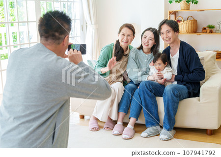 Three generations of family taking commemorative photos with smartphones Three generations of family taking commemorative photos with smartphones 107941792