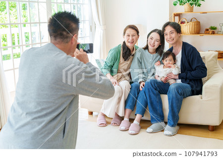 Three generations of family taking commemorative photos with smartphones Three generations of family taking commemorative photos with smartphones 107941793