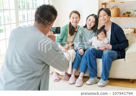 Three generations of family taking commemorative photos with smartphones Three generations of family taking commemorative photos with smartphones 107941794