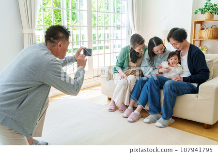 Three generations of family taking commemorative photos with smartphones Three generations of family taking commemorative photos with smartphones 107941795