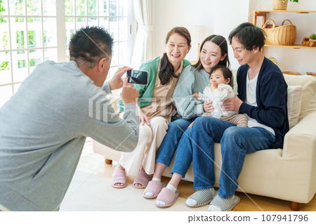Three generations of family taking commemorative photos with smartphones Three generations of family taking commemorative photos with smartphones 107941796