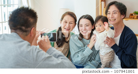 Three generations of family taking commemorative photos with smartphones 107941801