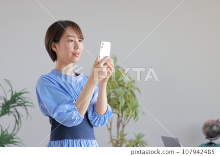 短髮年輕女子在辦公室看智慧型手機 1 短髮年輕女子在辦公室看智慧型手機 1 107942485