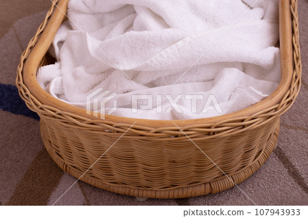 Used towel in a wicker basket 107943933