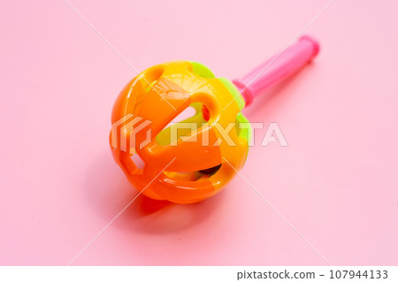 Colorful baby rattle on pink background. Colorful baby rattle on pink background. 107944133