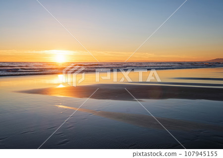 Atlantic ocean sunset with surging waves at Fonte da Telha beach, Costa da Caparica, Portugal 107945155