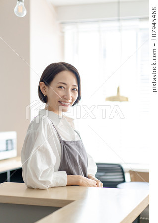 有圍裙的微笑的一名婦女 107945468