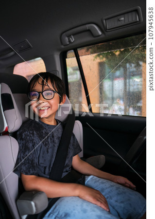 A boy in a car gets wet. 107945638
